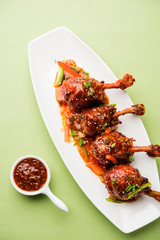 Szechuan Chicken which is a popular Indo-Chinese non vegetarian recipe. served in a plate with chilli sauce. selective focus