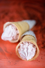 Beautiful and appetizing meringue ice-cream cake. Coral background, fashionable color in 2019.