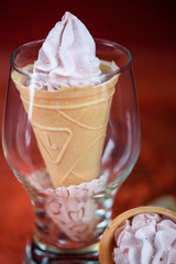 Beautiful and appetizing meringue ice-cream cake. Coral background, fashionable color in 2019.