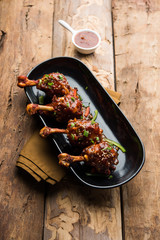 Szechuan Chicken which is a popular Indo-Chinese non vegetarian recipe. served in a plate with chilli sauce. selective focus