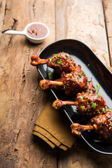 Szechuan Chicken which is a popular Indo-Chinese non vegetarian recipe. served in a plate with chilli sauce. selective focus