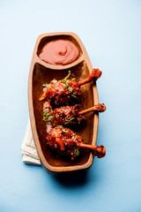 Szechuan Chicken which is a popular Indo-Chinese non vegetarian recipe. served in a plate with chilli sauce. selective focus