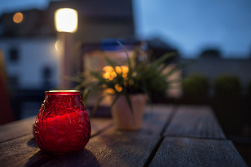red glass candlestick on a table in a street cafe
