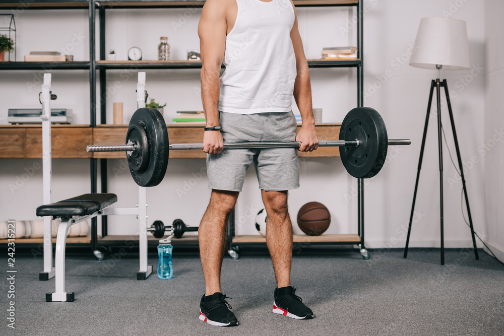 Wall mural cropped view of muscular man workout in home gym