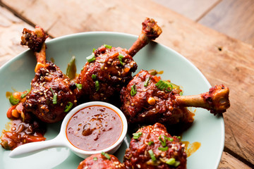 Szechuan Chicken which is a popular Indo-Chinese non vegetarian recipe. served in a plate with...
