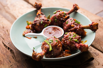 Szechuan Chicken which is a popular Indo-Chinese non vegetarian recipe. served in a plate with chilli sauce. selective focus