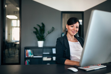 Elegant businesswoman at office desk.