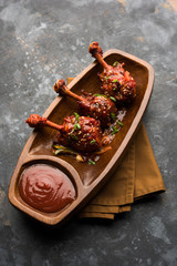 Szechuan Chicken which is a popular Indo-Chinese non vegetarian recipe. served in a plate with chilli sauce. selective focus