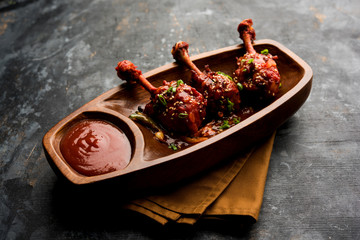 Szechuan Chicken which is a popular Indo-Chinese non vegetarian recipe. served in a plate with chilli sauce. selective focus