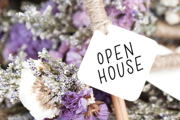 Open house word on card and purple flower background.