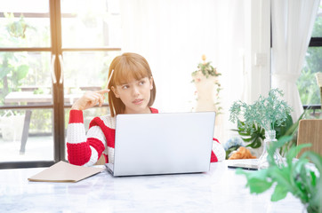 Beautiful woman's sofa is working on her laptop.Woman sitting in a white room..