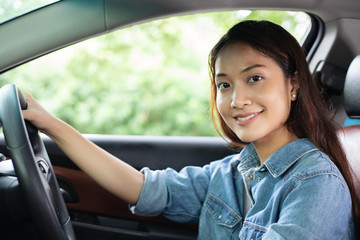 Beautiful Asian woman smiling and enjoying.driving a car on road for travel