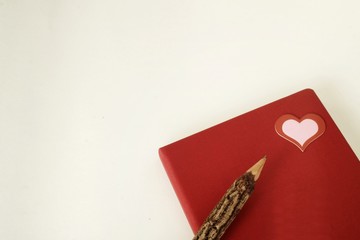 Writing a love story about Valentine's Day on the red diary .