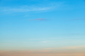 Natural sky background. Sky blue and orange light of the sun through the clouds in the sky