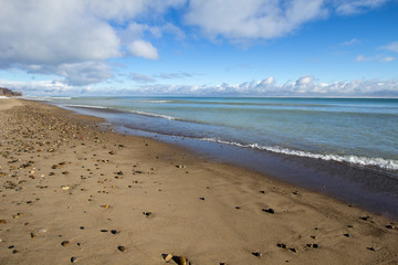 Blue Water Horizon. Beautiful blue water stretches to the horizon with a wide sandy beach in the foreground. Horizontal orientation with copy space.