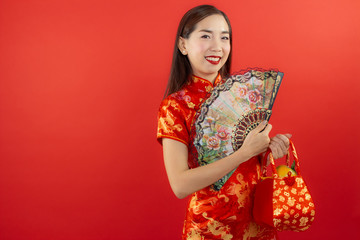 chinese new year beautiful happy smiley asia chiness girl ware Qipao Oriental Chic Cheongsam with red background copy space isolated