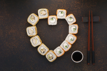 Heart shaped sushi rolls with chopsticks for Valentine's Day.