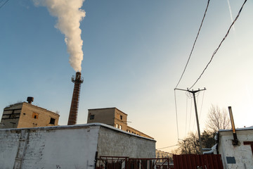 The old factory is still working. Its brick chimney fumes in the city center.