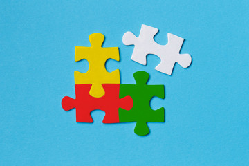 Four coloured puzzle pieces on blue background