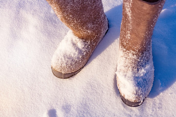 Winter shoes with a large size standing in the snow in the open air.  View from above.  Extreme cold. Photo with tinted instagram
