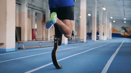 Disabled runner with bionic prosthesis, back view.