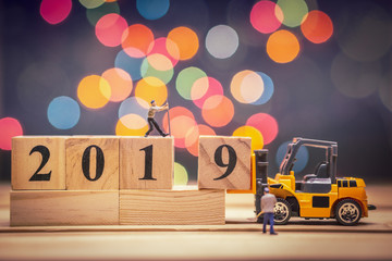 Miniature forklift lift up year 2019 wooden block on christmas background