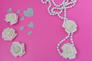white pearls with roses and hearts on a pink background