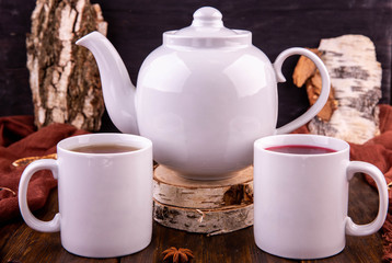 Green and berry tea with a teapot on cuts birch
