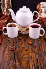 A tea teapot with cups of black and red tea