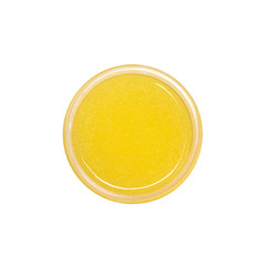 Yellow shower gel scrub container isolated on white background from top view. Sugaring
