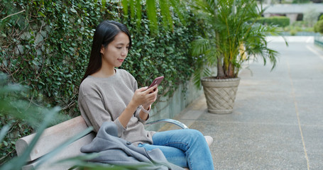 Woman use of mobile phone in city park