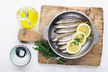 Smelt or sardine small sea fish for cooking healthy food with salt and lemon. Top view..