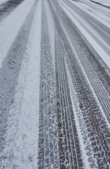 tire tracks in snow covered road  