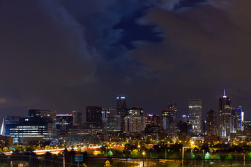 Denver Colorado downtown city skyline at night with clouds overhead
