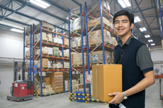 Worker carrying box in the warehouse (ฺBlur background) , Asian delivery man carrying boxes in the distribution warehouse (ฺBlur background)