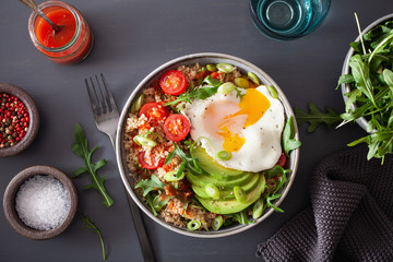 quinoa bowl with fried egg, avocado, tomato, rocket. Healthy vegetarian lunch