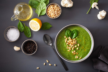 green creamy cauliflower spinach soup on gray background