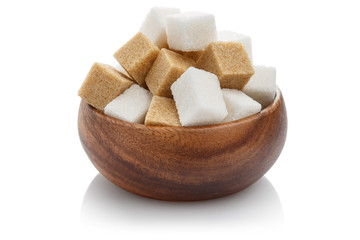 White and brown sugar cubes in a brown wooden bowl, isolated on white background