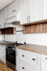  Luxury modern kitchen furniture in grey color and steel oven,fridge, sink, wooden tabletop. Gray...