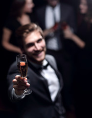 stylish young man raising his glass in a toast