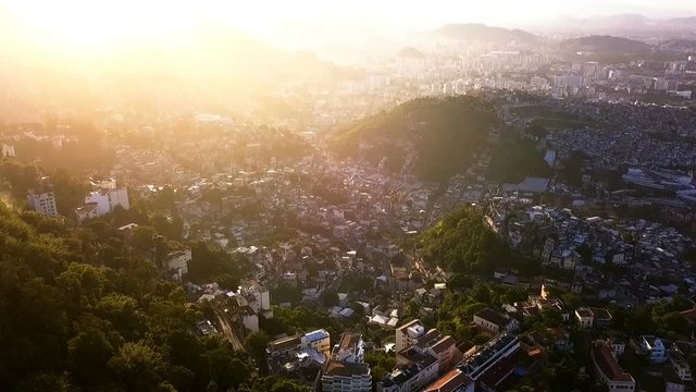Rio de Janeiro Brazil Aerial video footage of city. narrow streets of the poor favelas house on the hills. Beautiful golden hours sunset backlight.  landscape is romantically filled with sunshine