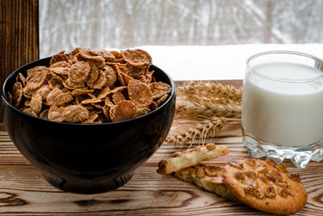 A healthy breakfast. Cereals are at the black plate on the wood background
