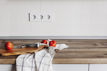 Cooking food on modern kitchen, knife on wooden cutting board with vegetables, spices on wooden...