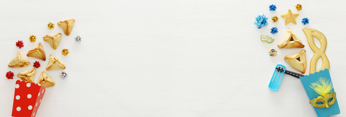 Purim celebration concept (jewish carnival holiday) over wooden white background. Banner.