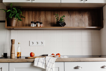 Cooking food on modern kitchen with furniture in grey color and wooden tabletop.  Knife on wooden...