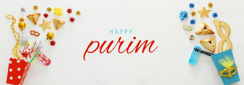 Purim celebration concept (jewish carnival holiday) over wooden white background. Banner.
