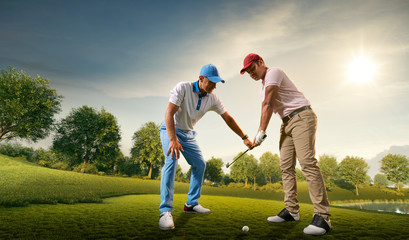 Male golf players on professional golf course. Golfer teaches to play golf
