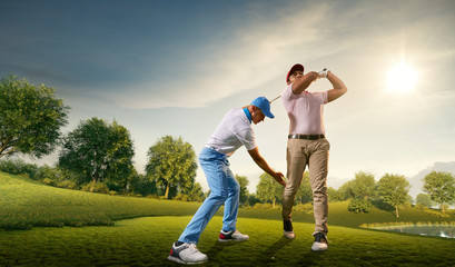 Male golf players on professional golf course. Golfer teaches to play golf