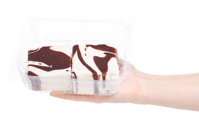 Cake in a plastic container in hand on a white background. Isolation