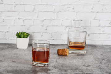 A glass of brandy or whiskey on a background of gray stone with truffles. Place for text